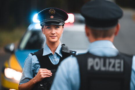 Eine Frau in Polizeikleidung schaut in die Kamera. 